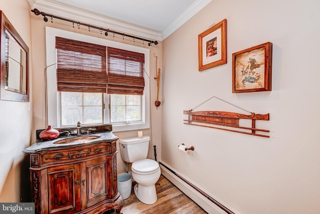 bathroom with toilet, ornamental molding, vanity, and hardwood / wood-style floors