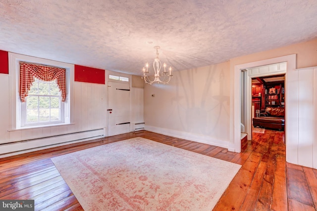 foyer featuring a baseboard radiator, a textured ceiling, a notable chandelier, and hardwood / wood-style flooring