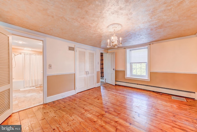 unfurnished bedroom with a baseboard radiator, a textured ceiling, crown molding, a notable chandelier, and light hardwood / wood-style flooring