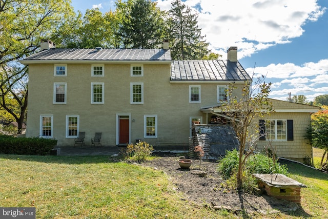 back of house featuring a patio and a yard