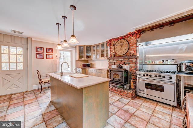 kitchen featuring designer stove, sink, hanging light fixtures, and a wealth of natural light