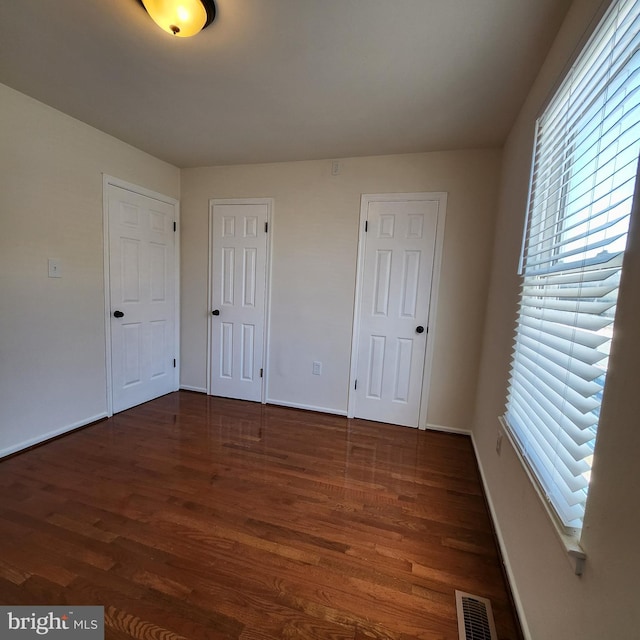 unfurnished room with dark wood-type flooring