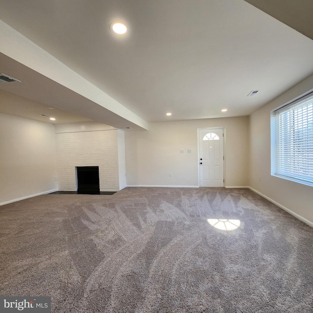 unfurnished living room with carpet and a large fireplace