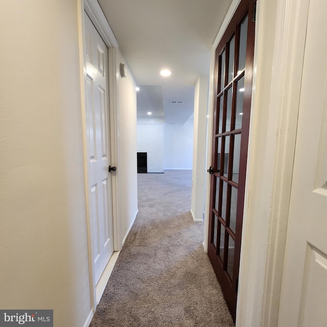 hallway featuring light colored carpet