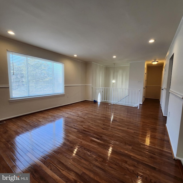 empty room with dark wood-type flooring and ornamental molding