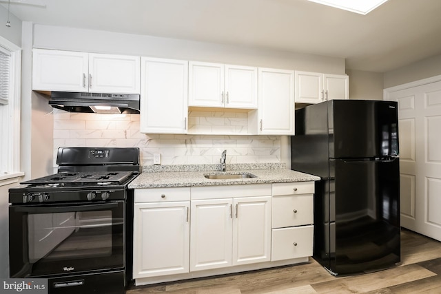 kitchen with decorative backsplash, sink, black appliances, light hardwood / wood-style floors, and white cabinetry