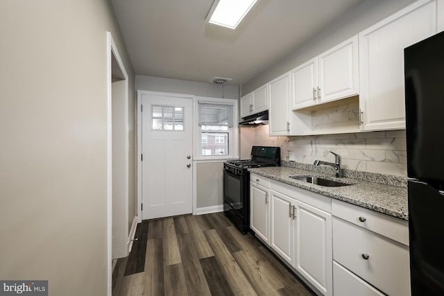 kitchen with dark wood-type flooring, black appliances, sink, light stone counters, and white cabinetry