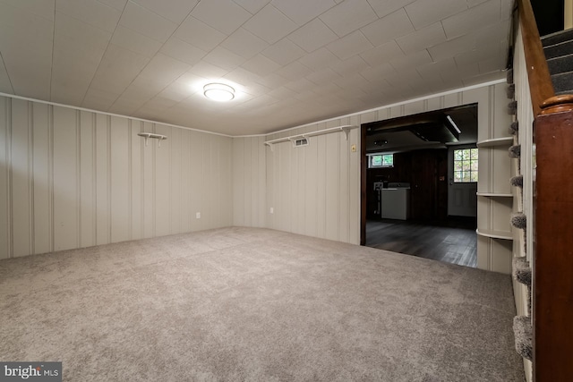 spare room featuring dark carpet and wood walls