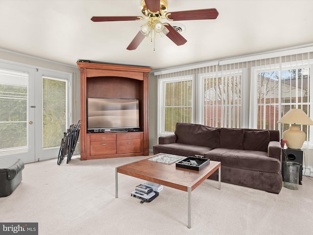 living room with french doors, ceiling fan, and light colored carpet