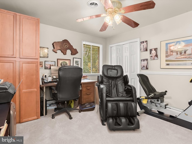 carpeted home office featuring ceiling fan