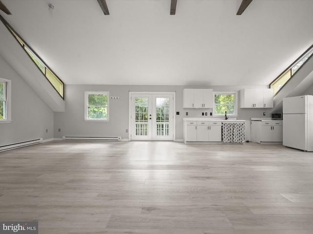 unfurnished living room featuring baseboard heating, high vaulted ceiling, and plenty of natural light