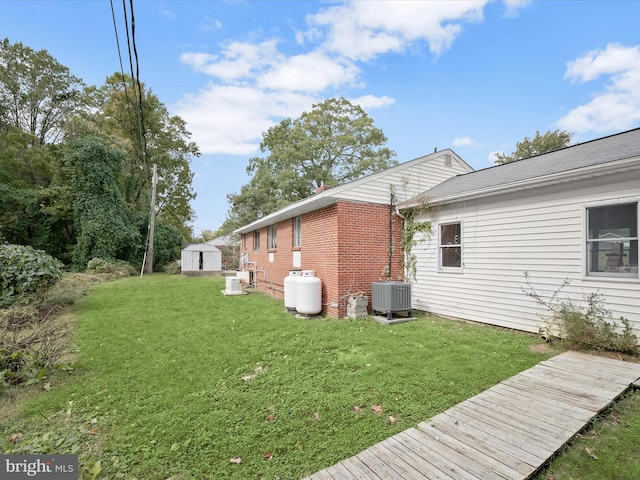 view of side of home with a shed, an outbuilding, a yard, and cooling unit