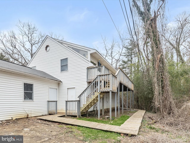 rear view of house featuring a wooden deck and stairs