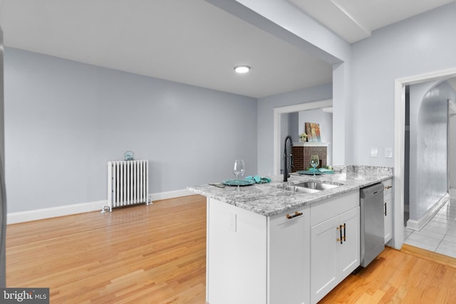 kitchen with white cabinetry, radiator heating unit, dishwasher, light stone countertops, and sink