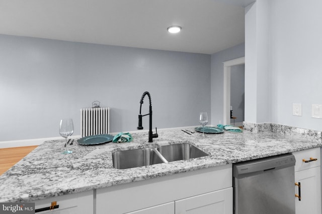 kitchen with white cabinets, dishwasher, light stone countertops, and sink