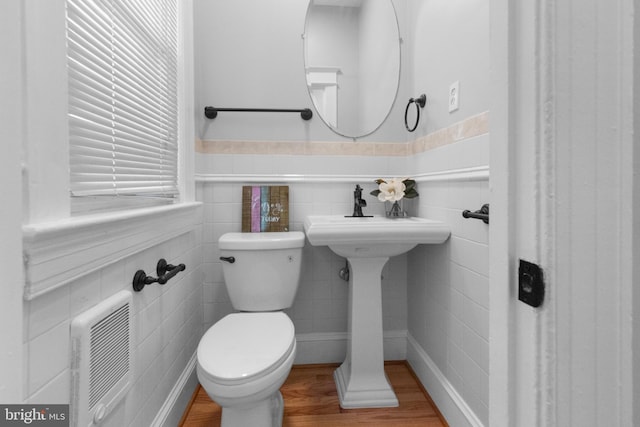 bathroom featuring heating unit, wood-type flooring, and toilet