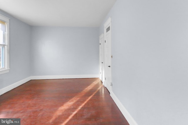 unfurnished room with dark hardwood / wood-style floors