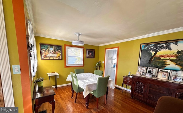 dining area with ornamental molding and hardwood / wood-style flooring