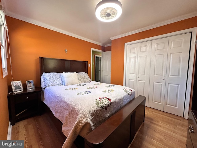 bedroom featuring crown molding, light hardwood / wood-style flooring, and a closet