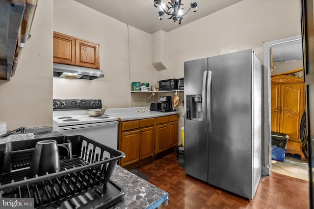 kitchen featuring electric stove, dark parquet flooring, stainless steel fridge, and a chandelier