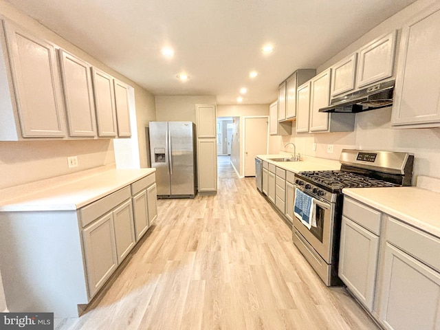 kitchen featuring appliances with stainless steel finishes, sink, and light wood-type flooring