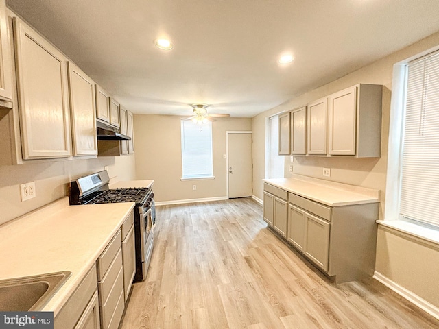 kitchen with light hardwood / wood-style floors, gas range, sink, and ceiling fan