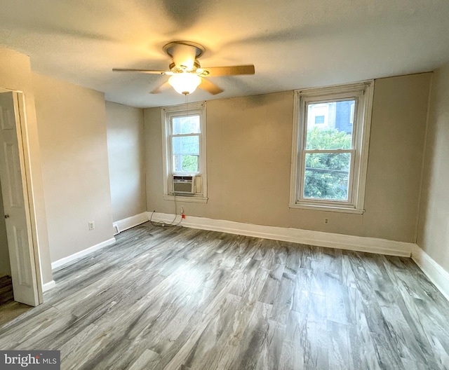 spare room with a wealth of natural light, light hardwood / wood-style flooring, and ceiling fan