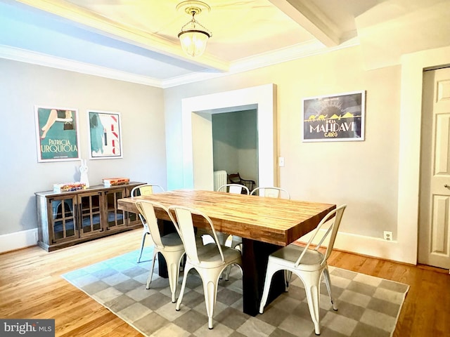 dining area with radiator, light wood-type flooring, and crown molding