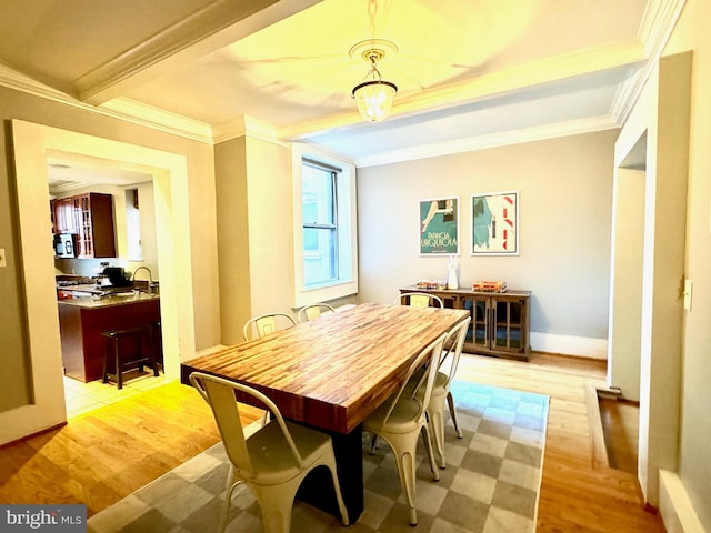 dining area with crown molding and light hardwood / wood-style flooring