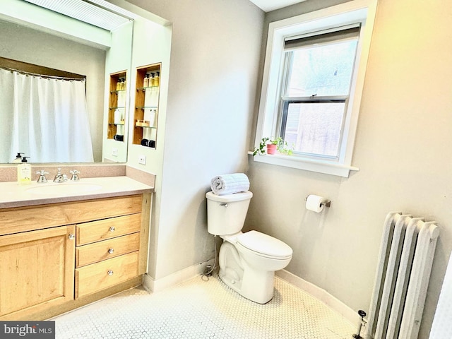 bathroom featuring tile patterned floors, vanity, radiator, and toilet