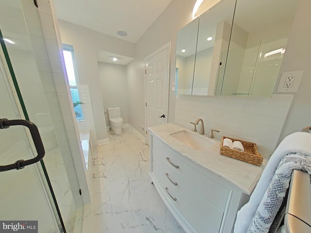 bathroom featuring vanity, toilet, a shower with shower door, and backsplash