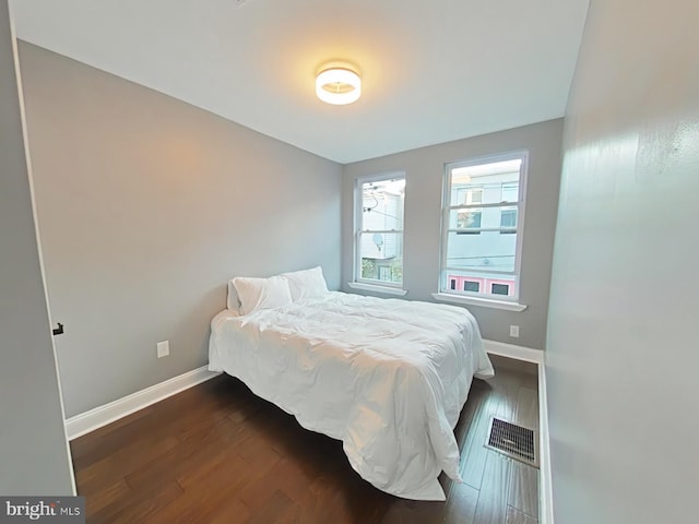 bedroom with dark hardwood / wood-style floors