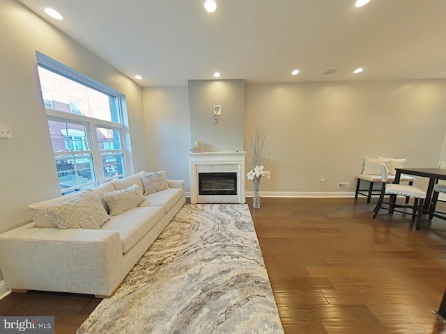 living room featuring a tile fireplace and dark hardwood / wood-style flooring