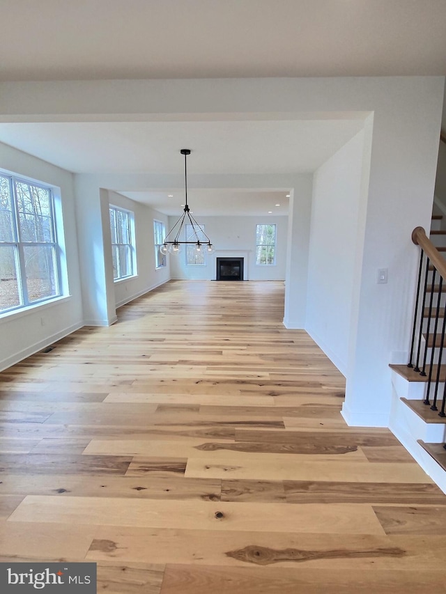 unfurnished dining area featuring light hardwood / wood-style flooring and a chandelier