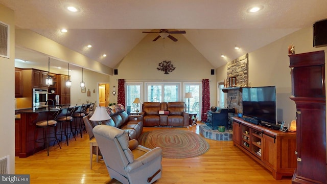 living room with ceiling fan, high vaulted ceiling, recessed lighting, visible vents, and light wood finished floors