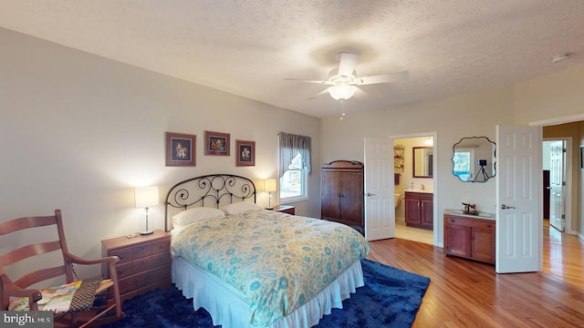 bedroom with a textured ceiling, wood finished floors, a ceiling fan, and ensuite bathroom