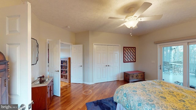 bedroom featuring access to exterior, a closet, a ceiling fan, a textured ceiling, and wood finished floors