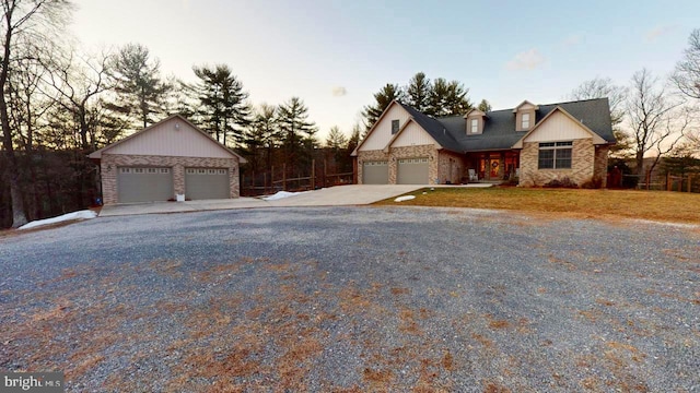 view of front facade featuring stone siding, brick siding, and a detached garage