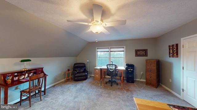 carpeted office with vaulted ceiling, a textured ceiling, baseboards, and ceiling fan