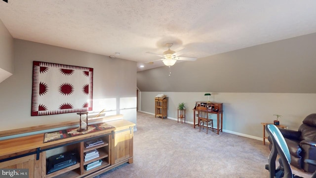 interior space with baseboards, lofted ceiling, ceiling fan, a textured ceiling, and carpet flooring