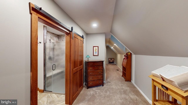 interior space featuring lofted ceiling, light carpet, baseboards, and a barn door