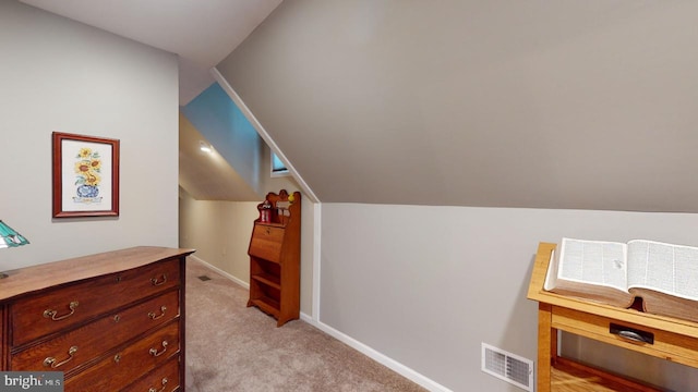 interior space with lofted ceiling, baseboards, visible vents, and light colored carpet