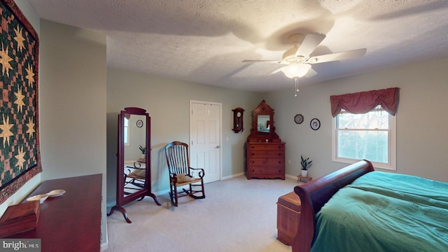 bedroom featuring light carpet, ceiling fan, a textured ceiling, and baseboards