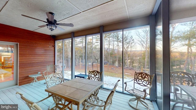 unfurnished sunroom featuring ceiling fan