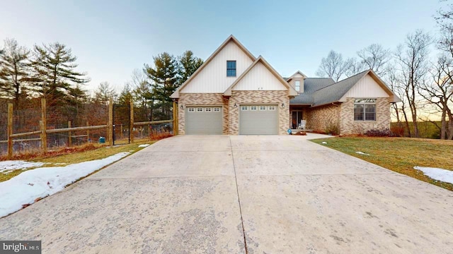 view of front facade with a garage, concrete driveway, fence, a front yard, and brick siding