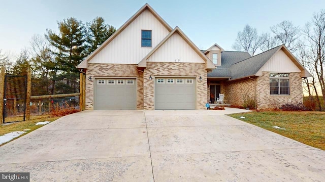 view of front of house with a front yard, brick siding, driveway, and fence