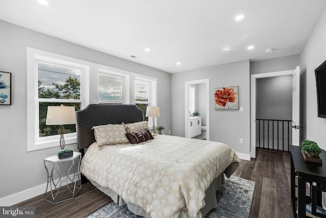 bedroom with ensuite bathroom and dark hardwood / wood-style flooring