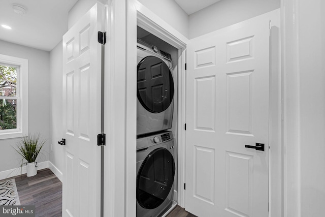 laundry area with stacked washer / dryer and dark hardwood / wood-style floors