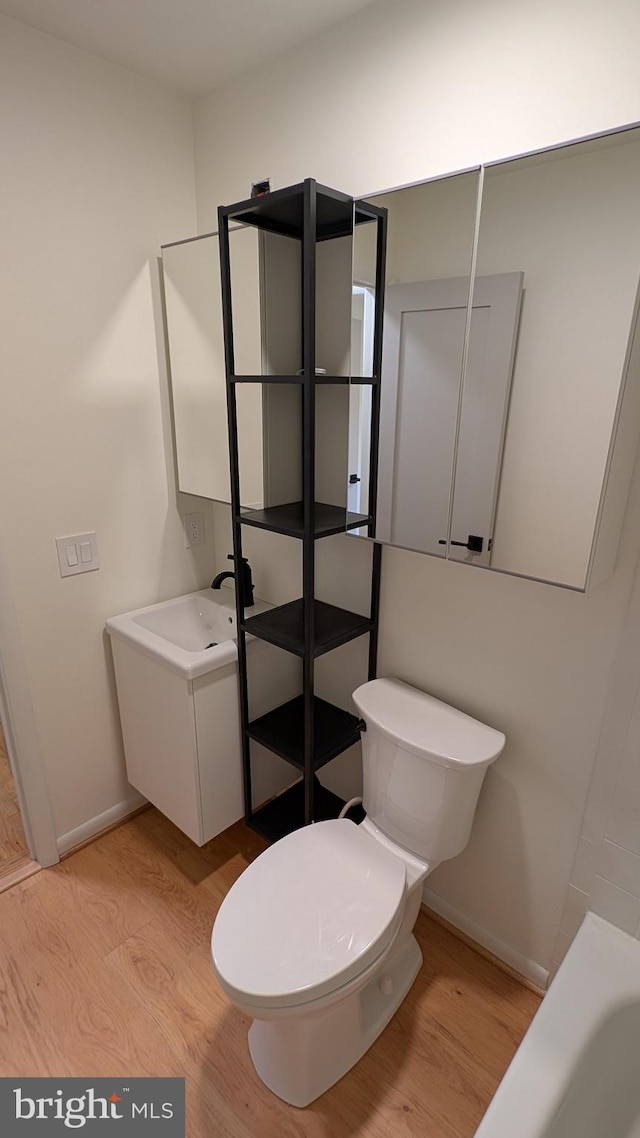 bathroom featuring wood-type flooring, vanity, and toilet