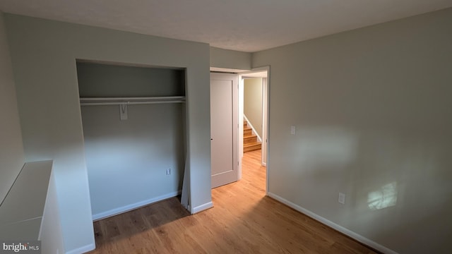 unfurnished bedroom featuring light hardwood / wood-style floors and a closet